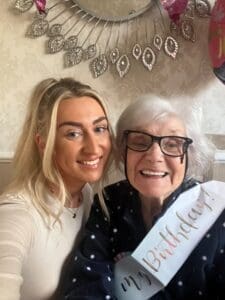 Nat pictured with her Nan, who is wearing a birthday sash. 