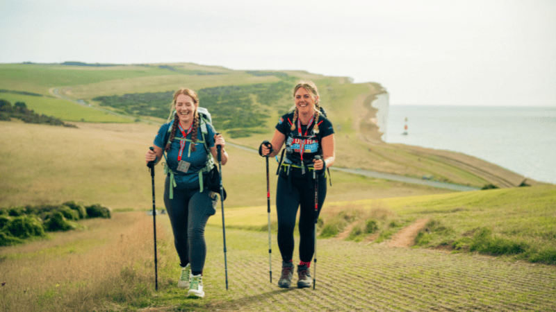 Two women walking along the south coast path
