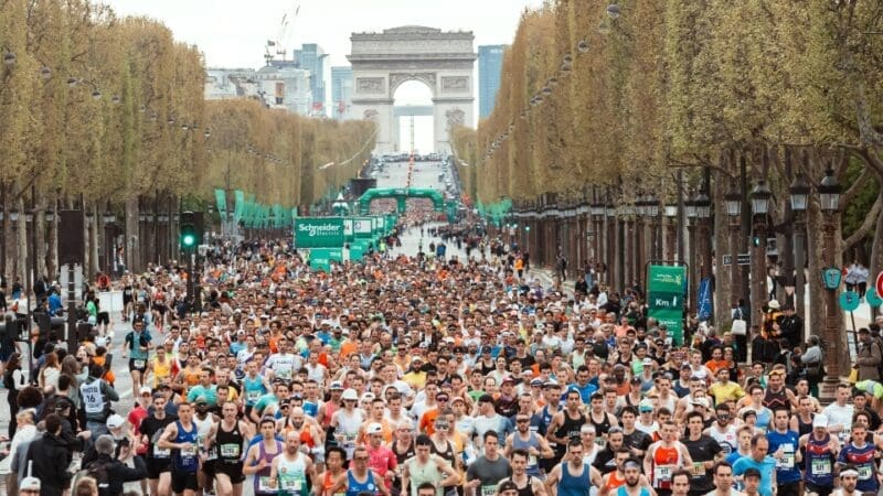 a crowd or runners running the paris marathon route