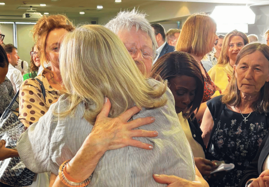 Lesley who cares for her husband Malcolm hugging Baroness Casey, Chair of the Independent Commission on Adult Social Care
