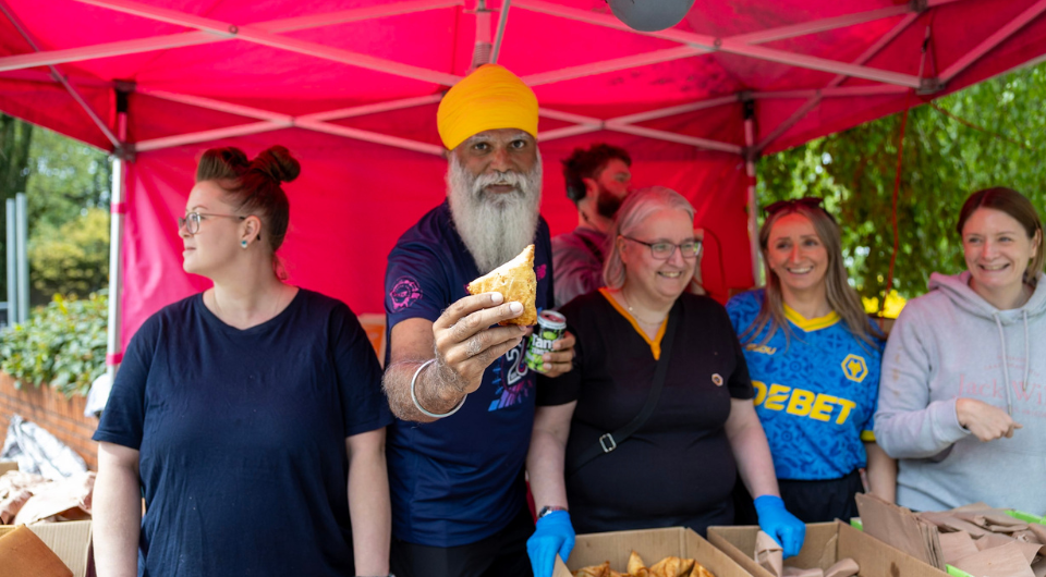 Manny handing out a samosa